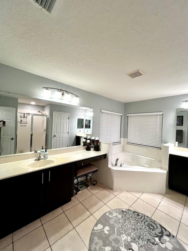 bathroom featuring visible vents, a shower stall, a garden tub, tile patterned floors, and vanity