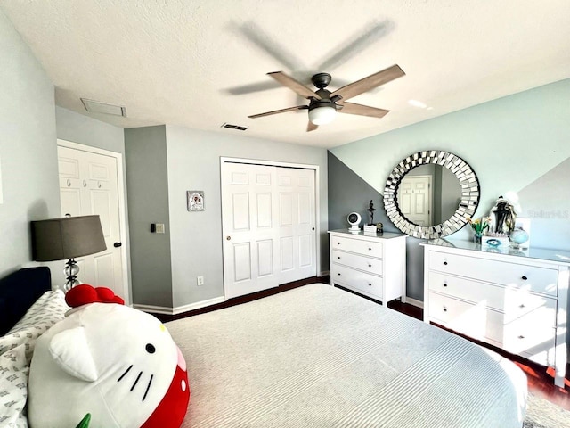 bedroom with visible vents, ceiling fan, baseboards, wood finished floors, and a closet