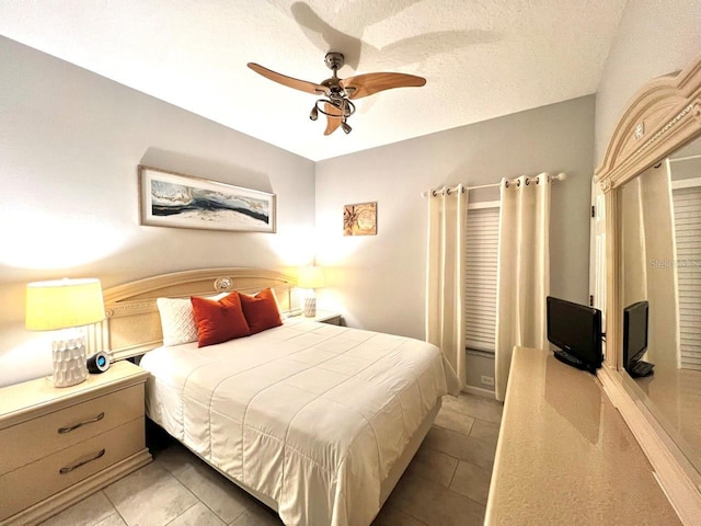 bedroom featuring a textured ceiling and a ceiling fan