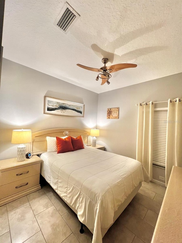 bedroom with visible vents, a textured ceiling, and ceiling fan