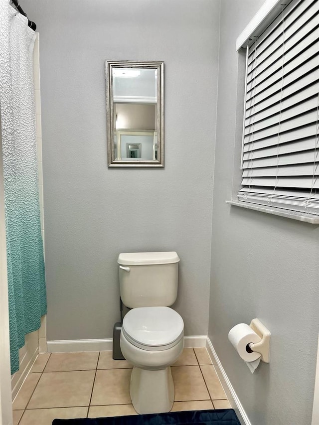 full bathroom with tile patterned floors, baseboards, and toilet