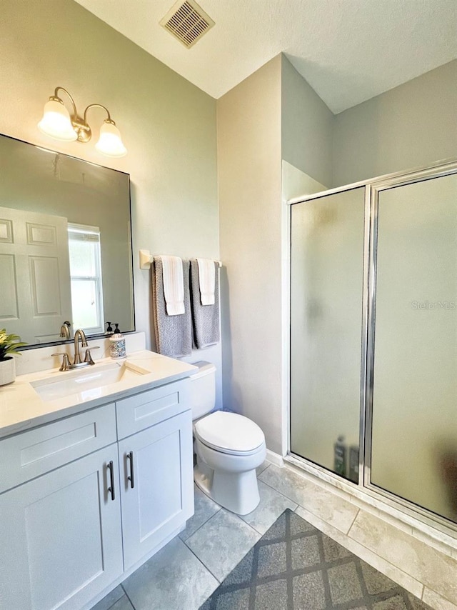 full bath featuring tile patterned flooring, visible vents, a shower stall, toilet, and vanity