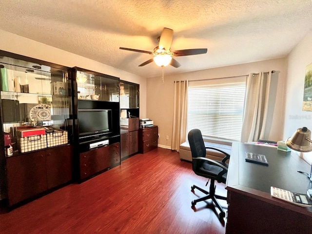 office with baseboards, a textured ceiling, dark wood-type flooring, and a ceiling fan