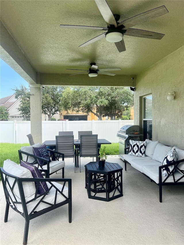 view of patio with grilling area, a ceiling fan, outdoor lounge area, and fence