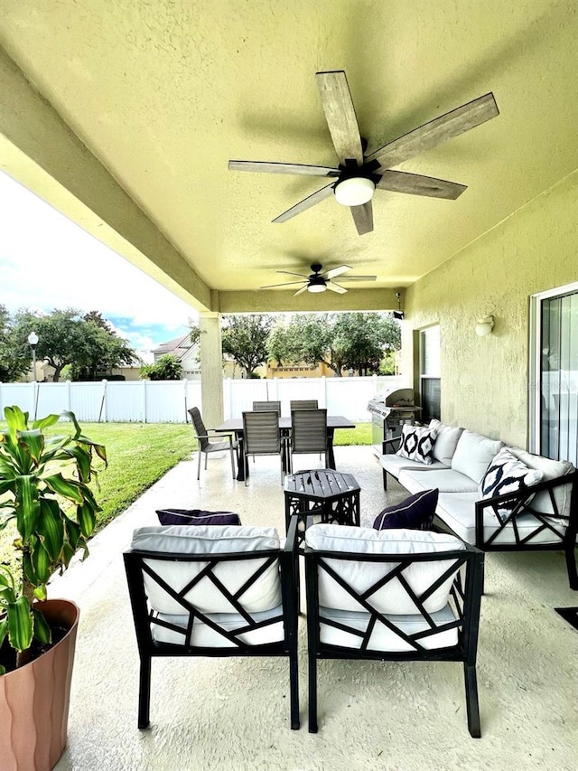 view of patio with outdoor dining area, a ceiling fan, a fenced backyard, and an outdoor hangout area