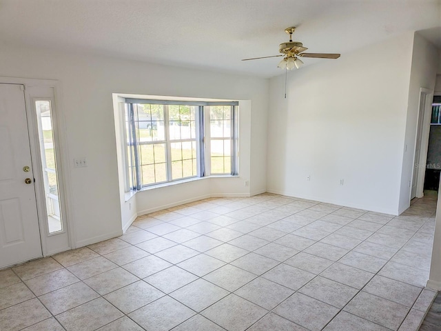 foyer entrance featuring light tile patterned floors, baseboards, and ceiling fan