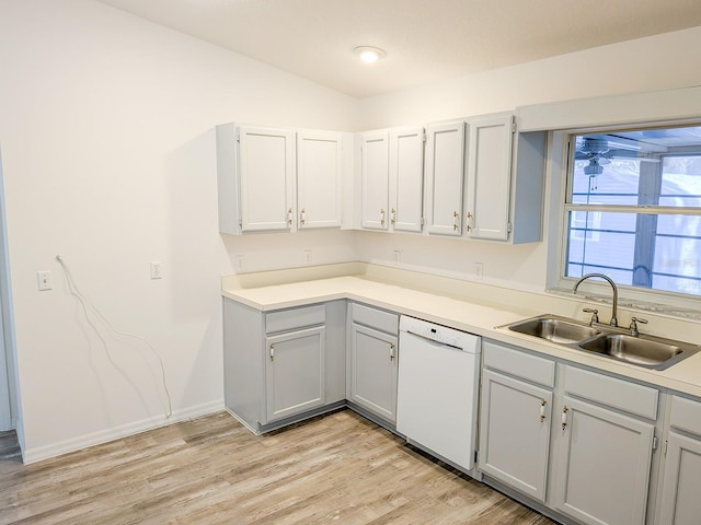 kitchen with light countertops, light wood-style flooring, white dishwasher, and a sink