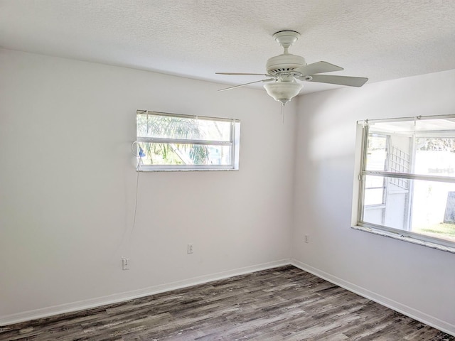 empty room with baseboards, a textured ceiling, a ceiling fan, and wood finished floors