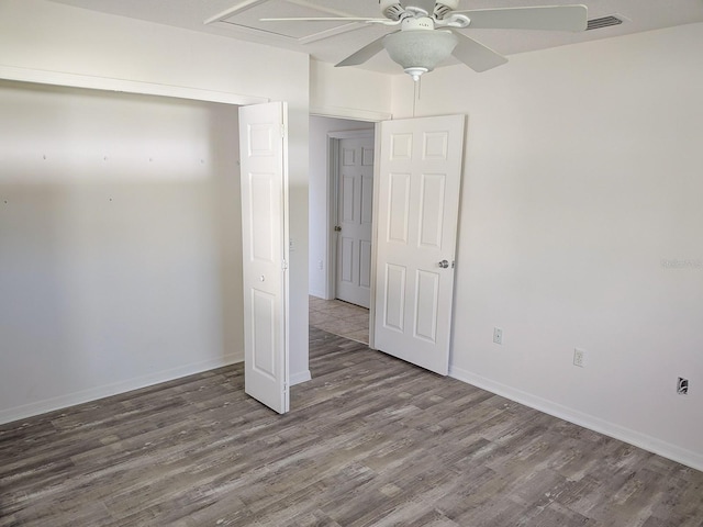 unfurnished bedroom with visible vents, a ceiling fan, wood finished floors, a closet, and baseboards