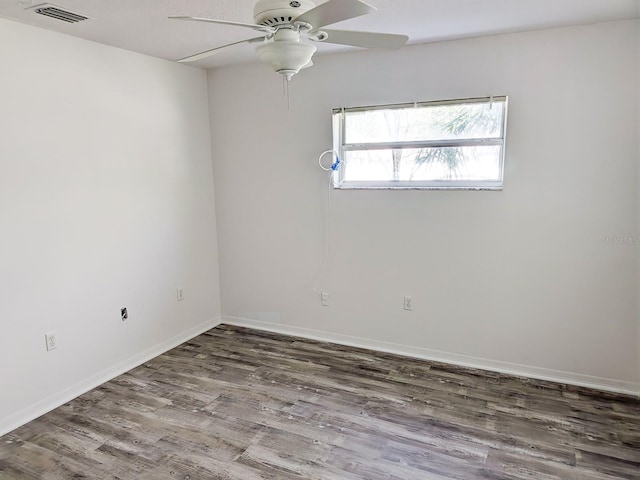 unfurnished room featuring visible vents, wood finished floors, baseboards, and ceiling fan