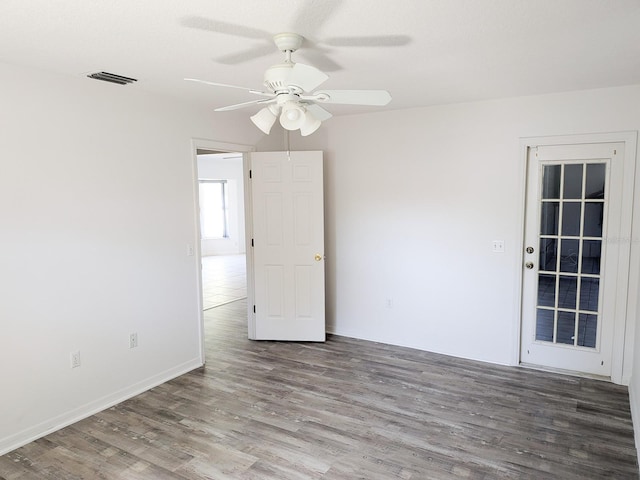 unfurnished room with visible vents, baseboards, ceiling fan, and wood finished floors