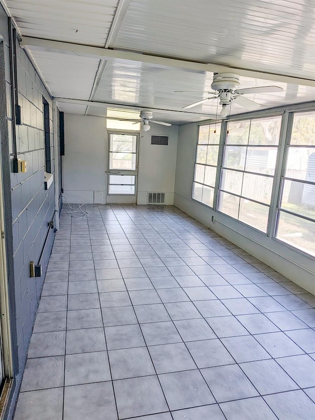 unfurnished sunroom with visible vents and ceiling fan