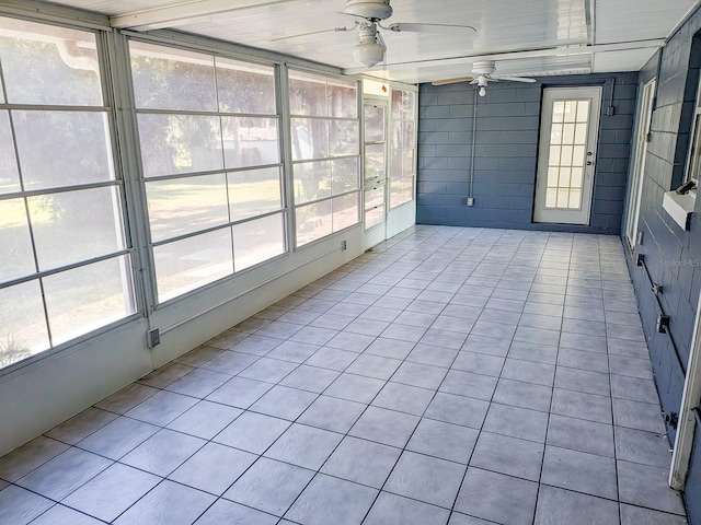 unfurnished sunroom featuring plenty of natural light and a ceiling fan