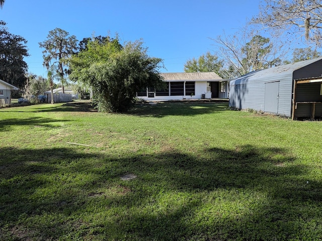 view of yard featuring an outbuilding and a sunroom