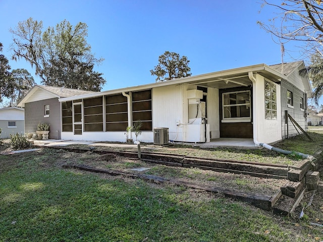 back of property featuring a yard, central air condition unit, and a sunroom