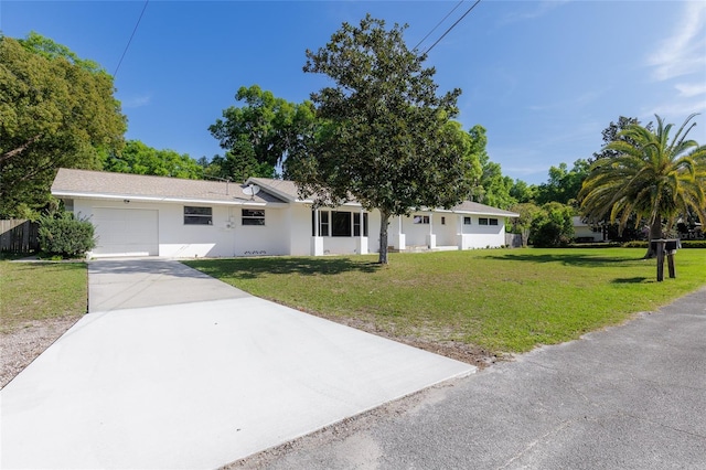 single story home featuring a front lawn, a garage, driveway, and stucco siding