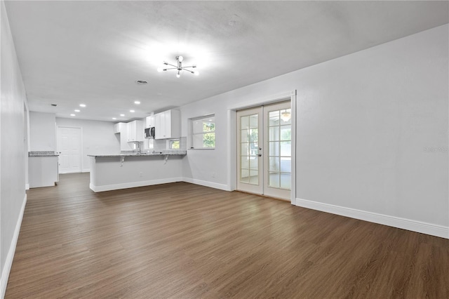 unfurnished living room featuring dark wood finished floors, recessed lighting, french doors, and baseboards