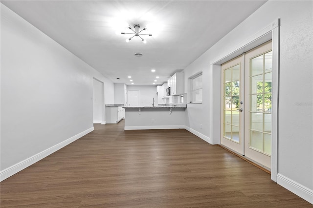 unfurnished living room featuring a sink, baseboards, dark wood-style floors, and recessed lighting