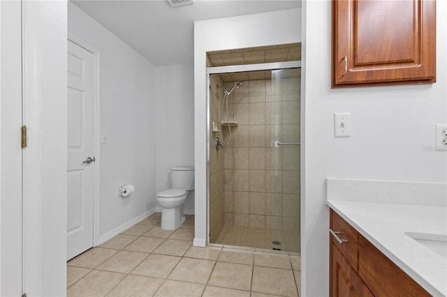 bathroom featuring tile patterned flooring, a stall shower, toilet, and vanity