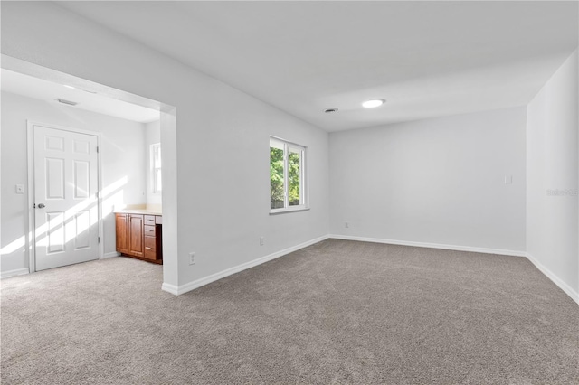 carpeted spare room featuring baseboards