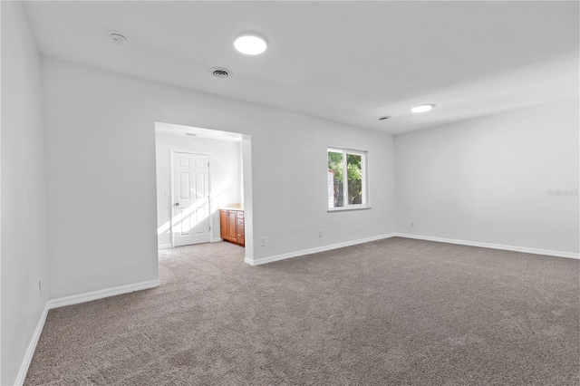 empty room featuring baseboards, visible vents, and carpet floors