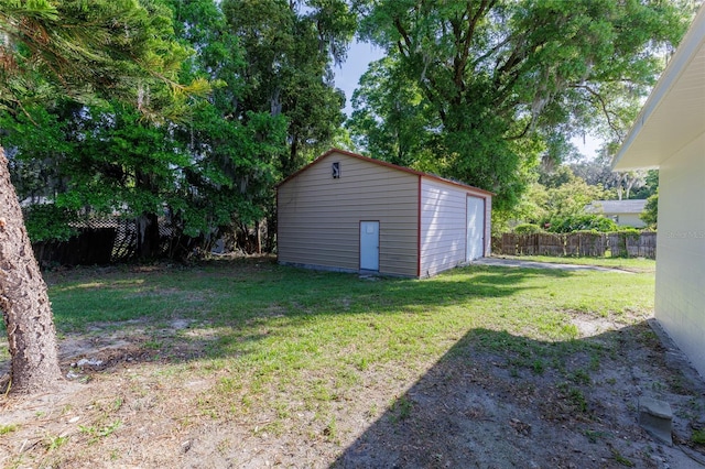 view of yard with an outdoor structure, fence, and a garage