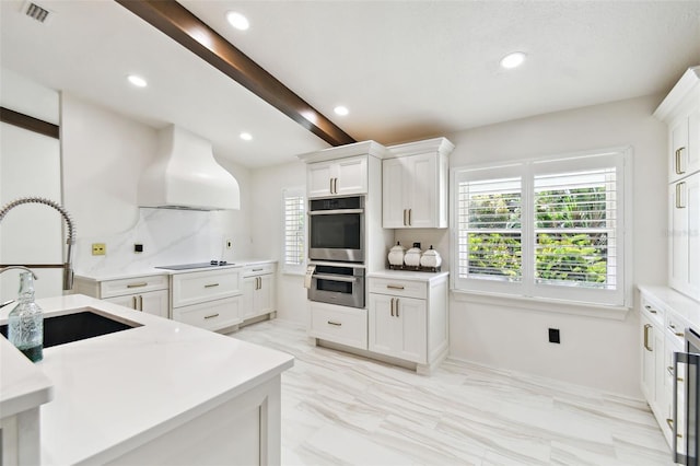 kitchen featuring stainless steel double oven, custom exhaust hood, a sink, light countertops, and black electric stovetop