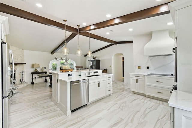 kitchen with range hood, lofted ceiling with beams, arched walkways, a sink, and stainless steel appliances