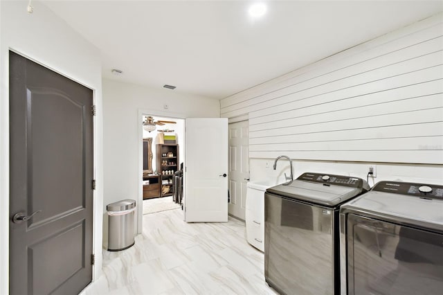 laundry room featuring visible vents, washer and clothes dryer, wood walls, laundry area, and marble finish floor