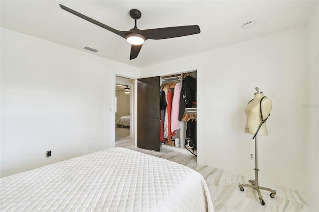 bedroom with a closet, wood finished floors, visible vents, and ceiling fan