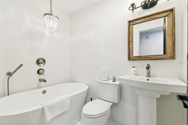 full bath featuring a soaking tub and toilet