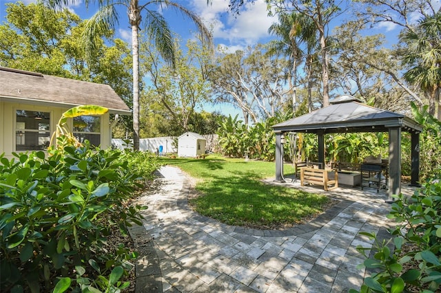 view of yard with a gazebo, a storage unit, an outdoor structure, and a patio area