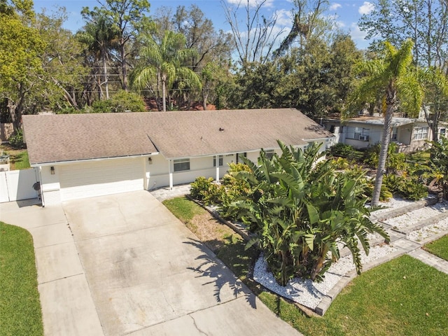 single story home featuring fence, roof with shingles, an attached garage, stucco siding, and concrete driveway