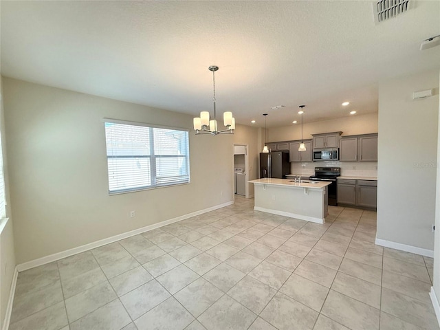 kitchen featuring a center island with sink, an inviting chandelier, gray cabinetry, black appliances, and light countertops