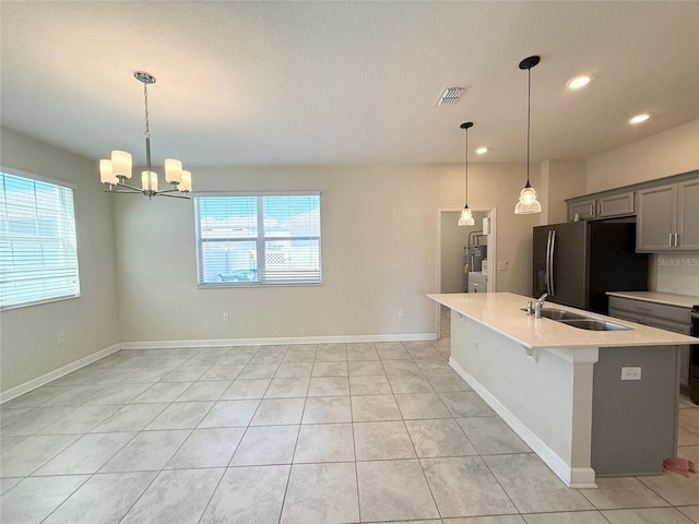 kitchen featuring visible vents, a sink, light countertops, a wealth of natural light, and black refrigerator with ice dispenser