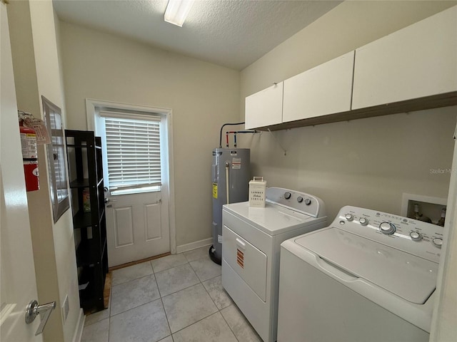 laundry area with washing machine and clothes dryer, electric water heater, light tile patterned floors, cabinet space, and a textured ceiling