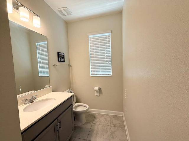 half bathroom featuring tile patterned flooring, visible vents, baseboards, toilet, and vanity