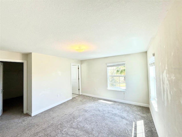 interior space with baseboards, carpet floors, and a textured ceiling