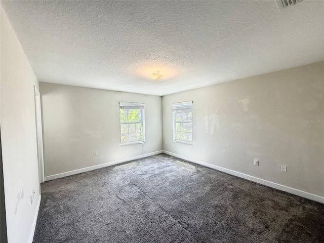 unfurnished room featuring baseboards, a textured ceiling, and carpet flooring