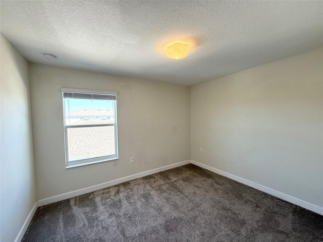 unfurnished room featuring baseboards, carpet floors, and a textured ceiling