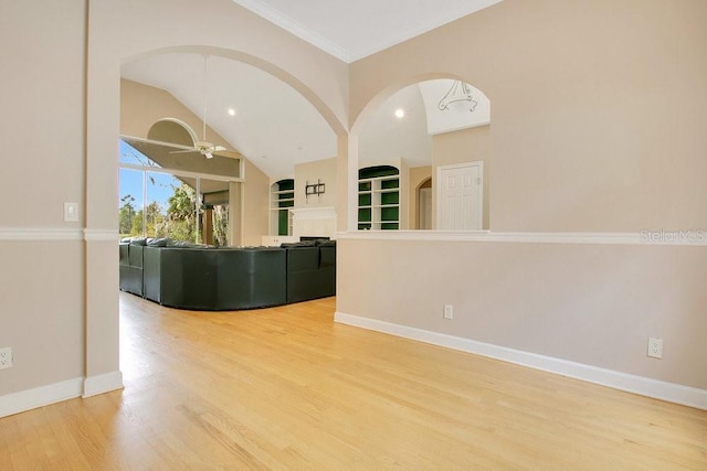 unfurnished living room with vaulted ceiling, baseboards, a ceiling fan, and wood finished floors