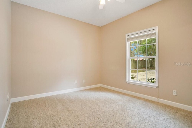 carpeted spare room with baseboards and ceiling fan