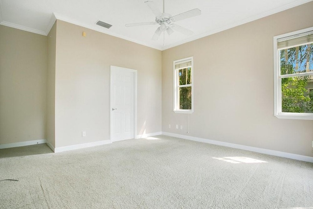 empty room with a ceiling fan, baseboards, visible vents, light carpet, and crown molding