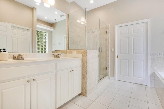 bathroom featuring tile patterned flooring, a shower stall, double vanity, and a sink