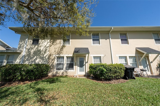townhome / multi-family property featuring stucco siding and a front yard