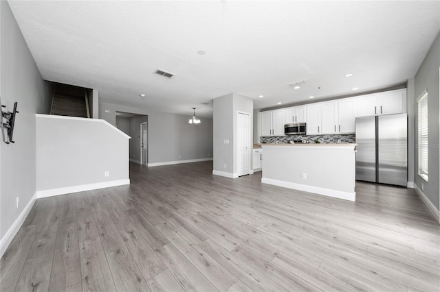 unfurnished living room featuring recessed lighting, visible vents, baseboards, and light wood finished floors
