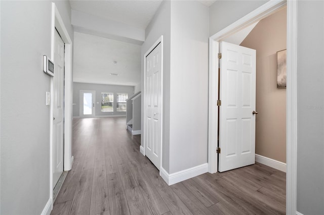 hallway with baseboards and wood finished floors
