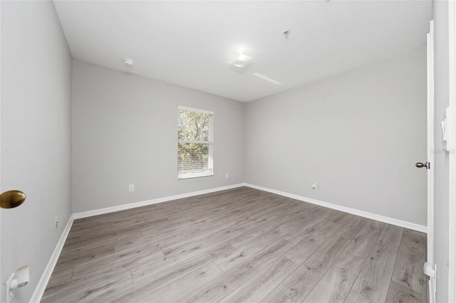 unfurnished room with baseboards and wood finished floors