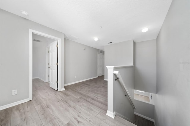 empty room featuring visible vents, wood finished floors, and baseboards