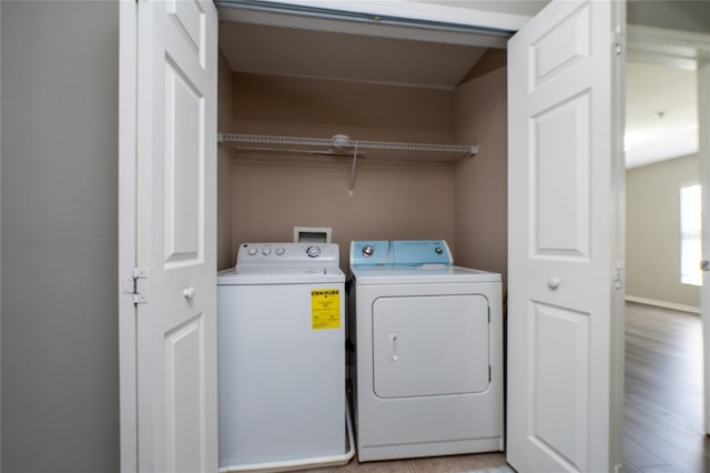 laundry area featuring light wood finished floors, laundry area, and washer and clothes dryer